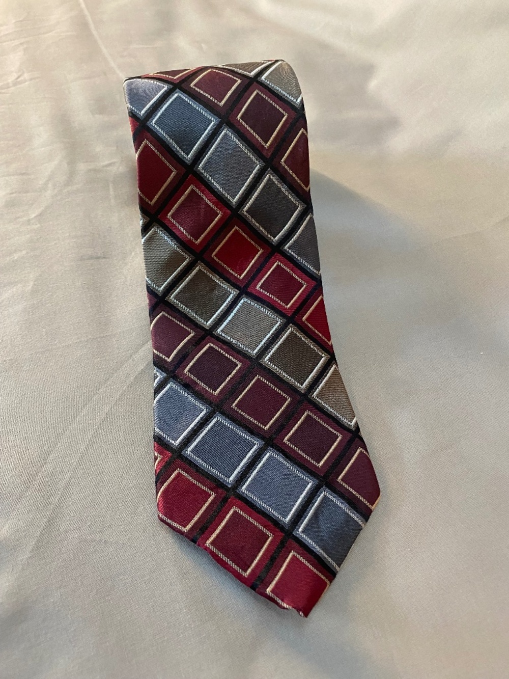 Access 100% Silk Necktie with diamond pattern of reds, gold and silver.